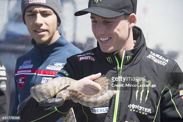 Pol Espargaro of Spain and Monster Yamaha Tech 3 jokes with a snake in paddock during previews ahead of the 2016 MotoGP of Australia at Phillip...