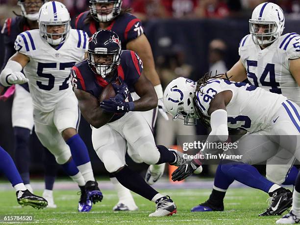 Lamar Miller of the Houston Texans carries the ball as Erik Walden of the Indianapolis Colts attempts to make the tackle in the first quarter during...