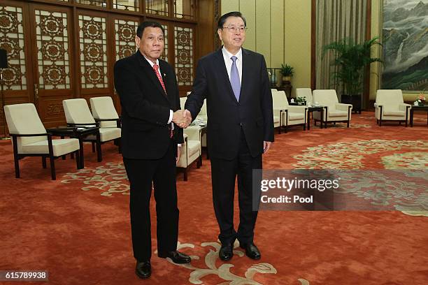 Philippines President Rodrigo Duterte shakes hands with Zhang Dejiang, Chairman of the Standing Committee of the National People's Congress of China...