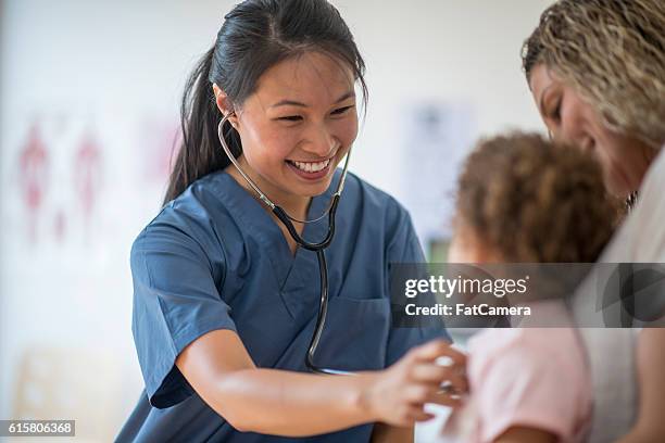 little girl at a check up with her mother - nurse child stockfoto's en -beelden