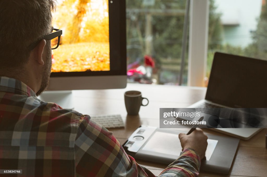 Graphic designer using digital tablet and computer