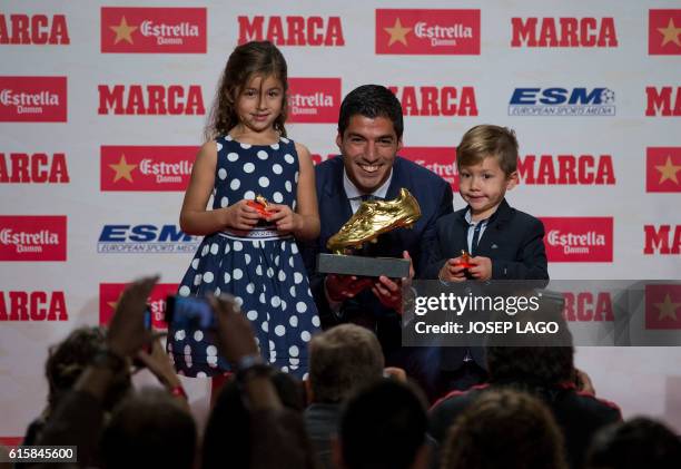 Barcelona's Uruguayan forward Luis Suarez poses with his children Delfina and Benjamin, after receiving the 2015-2016 Golden Shoe award to the...