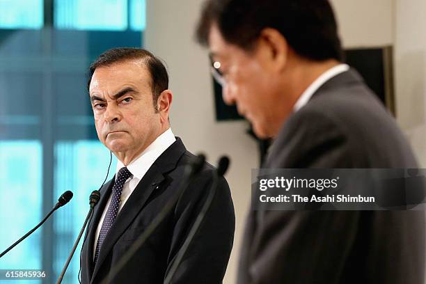 Nissan Motor Co Chairman and CEO Carlos Ghosn wacthes while Mitsubishi Motors Chairman and CEO Osamu Masuko speaks during a press conference on...