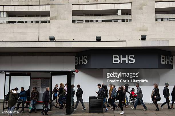 Shoppers walk past the boarded up BHS and wait for a bus at a bus stop on Oxford Street on October 20, 2016 in London, England. A unanimous vote in...