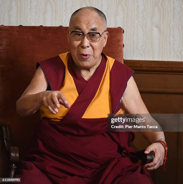 Dalai Lama gestures during a meeting with the Milan Archibishop Angelo Scola on October 20, 2016 in Milan, Italy. The Dalai Lama spiritual leader of...