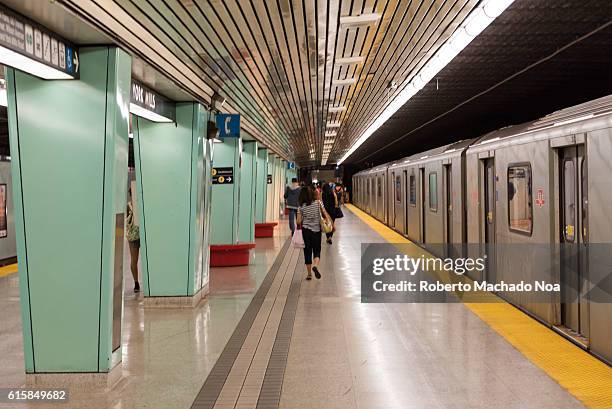 Or Toronto Transit Commission, subway station: Passengers and train on platform inside subway station in Toronto.