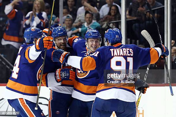 Anthony Beauvillier of the New York Islanders celebraes with teammates John Tavares, Dennis Seidenberg and Calvin de Haan after scoring a goal in the...