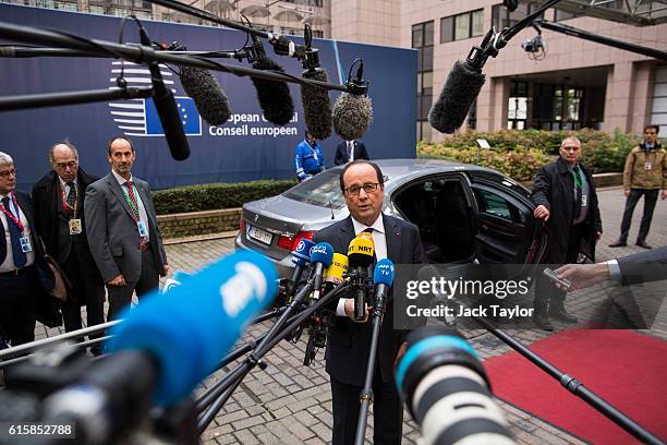 French President Francois Hollande addresses assembled media as he arrives at the Council of the European Union on the first day of a two day summit...