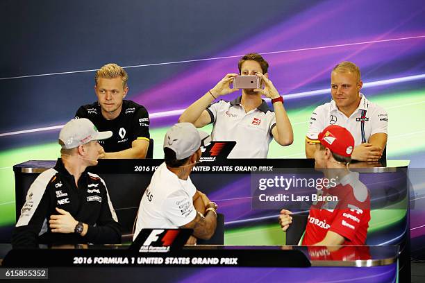 Romain Grosjean of France and Haas F1 takes a photo of Lewis Hamilton of Great Britain and Mercedes GP, Sebastian Vettel of Germany and Ferrari and...
