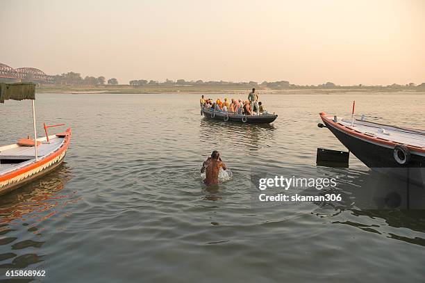 early morning indian people come to holy dip at ghat near ganga river benares varanasi india - ares god stockfoto's en -beelden