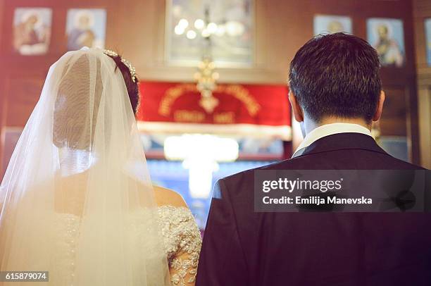 young couple in the church on their wedding day - church altar stock pictures, royalty-free photos & images