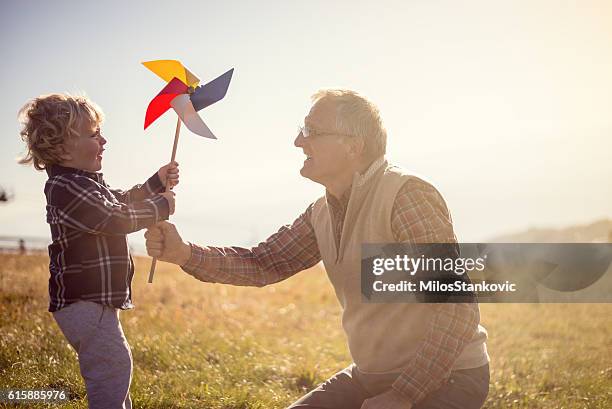 verspielter tag mit meinem opa - windrad natur wiese stock-fotos und bilder