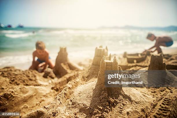 kids building sandcastles - sand castle stock pictures, royalty-free photos & images