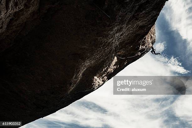 extreme rock climbing - overhangende rots stockfoto's en -beelden