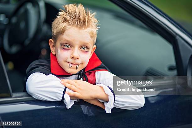 pequeño niño de halloween sonriendo fuera del coche - traje de época fotografías e imágenes de stock