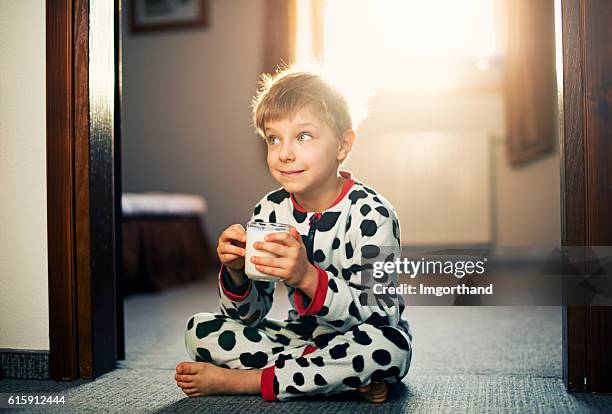 cute little boy drinking glass of milk in morning - nightwear stock pictures, royalty-free photos & images