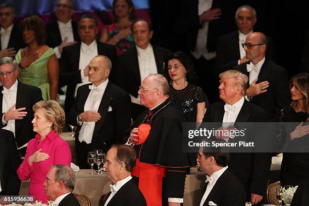 Cardinal Timothy Dolan stand between, Hillary Clinton and Donald Trump participate in ceremonies while attending the annual Alfred E. Smith Memorial...