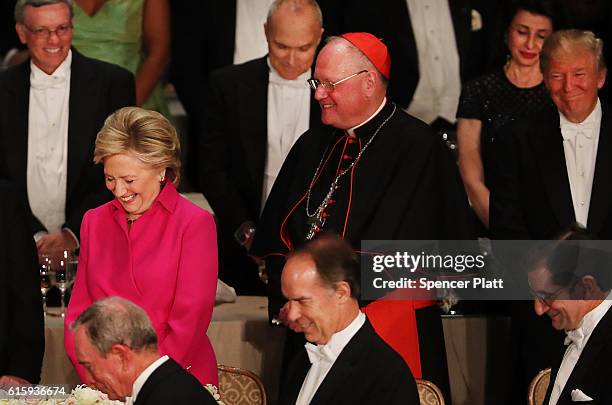 Cardinal Timothy Dolan stand between, Hillary Clinton and Donald Trump participate in a prayer while attending the annual Alfred E. Smith Memorial...