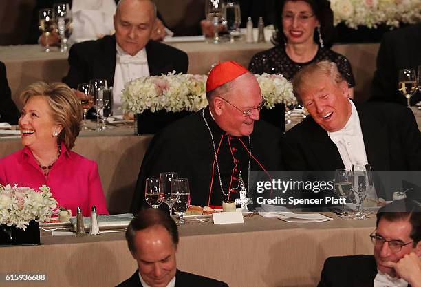 Cardinal Timothy Dolan sits between, Hillary Clinton and Donald Trump attend the annual Alfred E. Smith Memorial Foundation Dinner at the Waldorf...