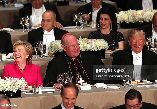 Cardinal Timothy Dolan sits between, Hillary Clinton and Donald Trump attend the annual Alfred E. Smith Memorial Foundation Dinner at the Waldorf...