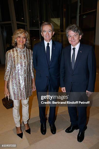 Owner of LVMH Luxury Group Bernard Arnault standing between his wife Helene and politician Thierry Breton attend the "Icones de l'Art Moderne, La...