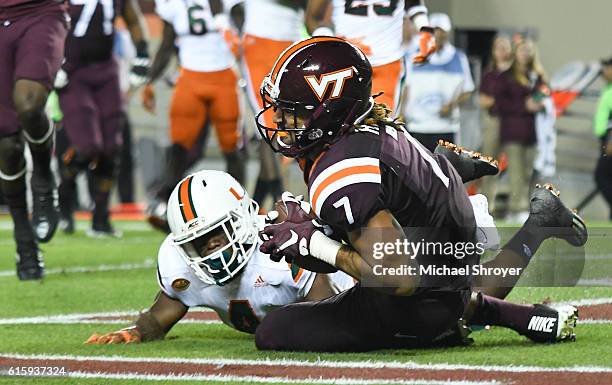 Tight end Bucky Hodges of the Virginia Tech Hokies catches a touchdown pass while being defended by defensive back Jaquan Johnson of the Miami...