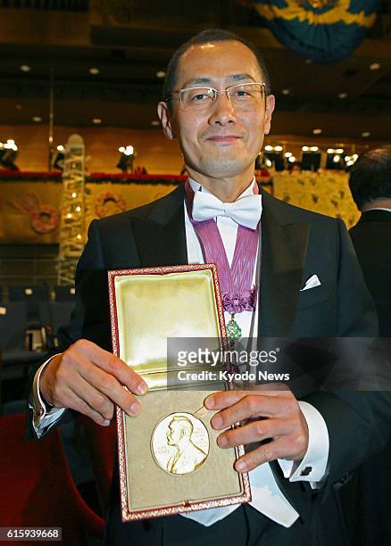 Sweden - Japanese stem cell researcher Shinya Yamanaka, a co-recipient of the 2012 Nobel Prize in medicine, shows his Nobel Prize medal after...