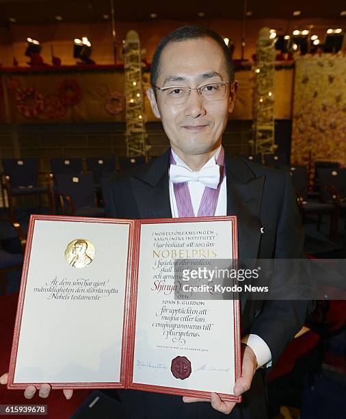 Sweden - Japanese stem cell researcher Shinya Yamanaka, a co-recipient of the 2012 Nobel Prize in medicine, shows his Nobel Prize diploma after...