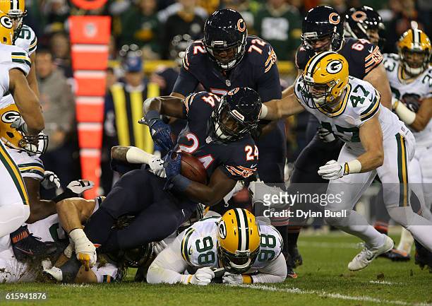 Running back Jordan Howard of the Chicago Bears carries the ball against defensive end Letroy Guion and inside linebacker Jake Ryan of the Green Bay...