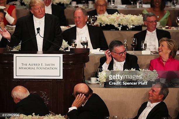 Hillary Clinton laughs as Donald Trump speaks at the annual Alfred E. Smith Memorial Foundation Dinner at the Waldorf Astoria on October 20, 2016 in...
