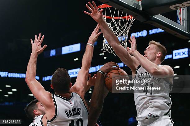 Justin Hamilton, Greivis Vasquez, and Joe Harris of the Brooklyn Nets defend a shot by Kyle O'Quinn of the New York Knicks during the second half of...