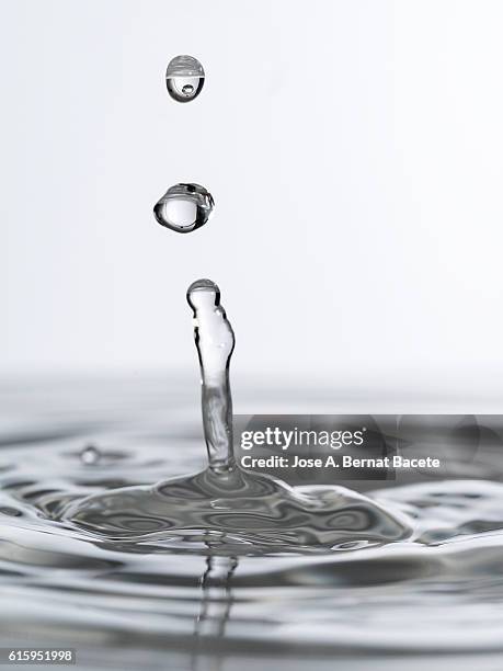 three drops in a row on impact on a calm water surface - slime ball stock pictures, royalty-free photos & images