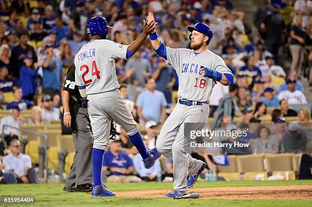 Dexter Fowler and Ben Zobrist of the Chicago Cubs celebrate after a three-run double in the eighth inning against the Los Angeles Dodgers in game...