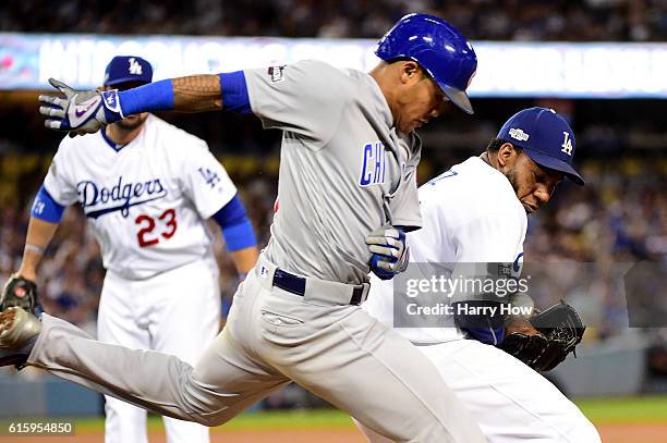 Pedro Baez of the Los Angeles Dodgers drops the ball as Addison Russell of the Chicago Cubs gets a single in the eighth inning in game five of the...