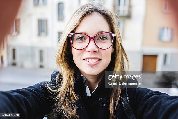 giovane donna carina con occhiali da vista scatta un selfie. - blonde woman selfie foto e immagini stock