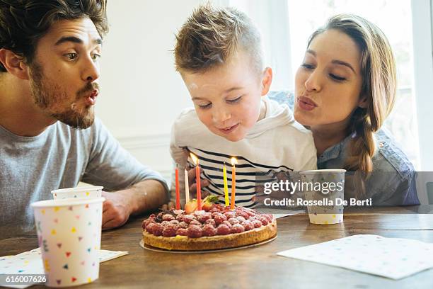 zu hause mit familie feiern geburtstag für kleine jungen - blowing out candles pov stock-fotos und bilder