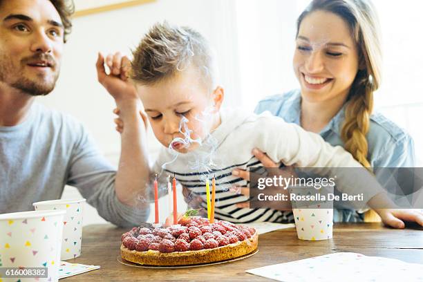 zu hause mit familie feiern geburtstag für kleine jungen - blowing out candles pov stock-fotos und bilder