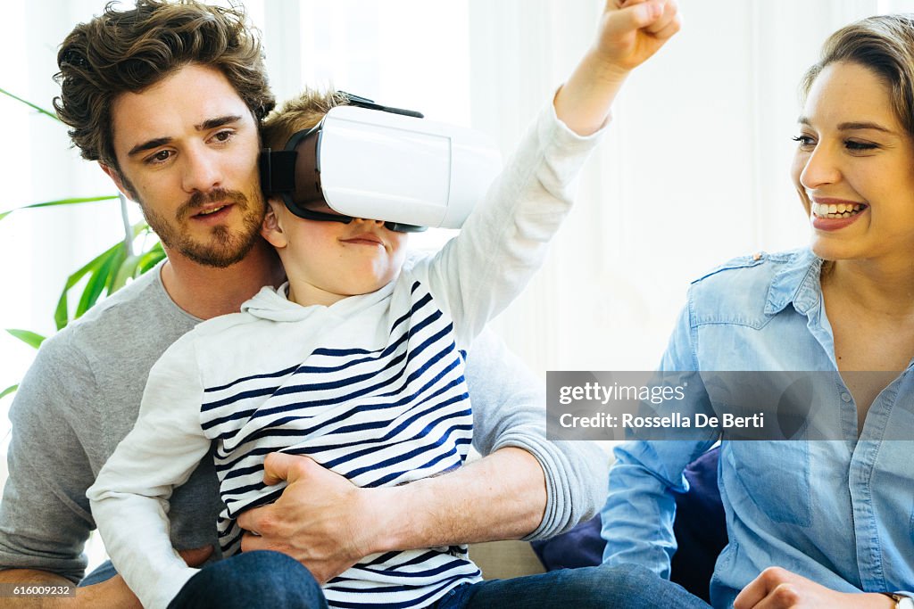 Family Experiencing Virtual Reality And Having Fan At Home