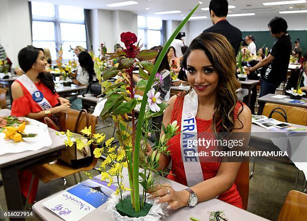 Miss France Khaoula Najine creates her Japanese trational flower arrangement at the Ikenobo headquarters in Tokyo on October 21, 2016. Seventy women...