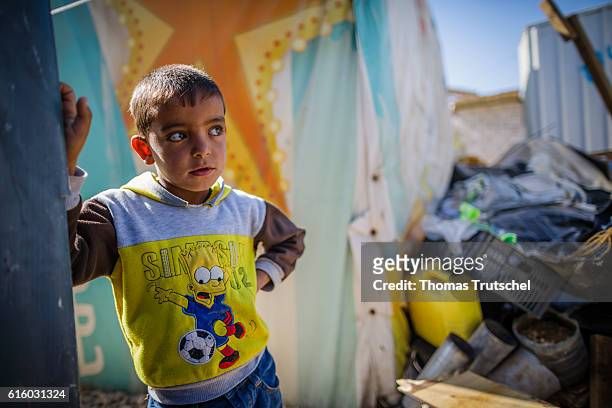 Bar Elias, Lebanon A Syrian boy stands in a refugee camp on the Bekaa plain next to a tent and wears a sweatshirt depicting Bart Simpson on October...