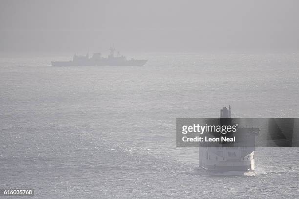 Russian Naval vessel appears through the mist behind a ferry in the English channel on October 21, 2016 near Dover, England. The Russian Navy's...