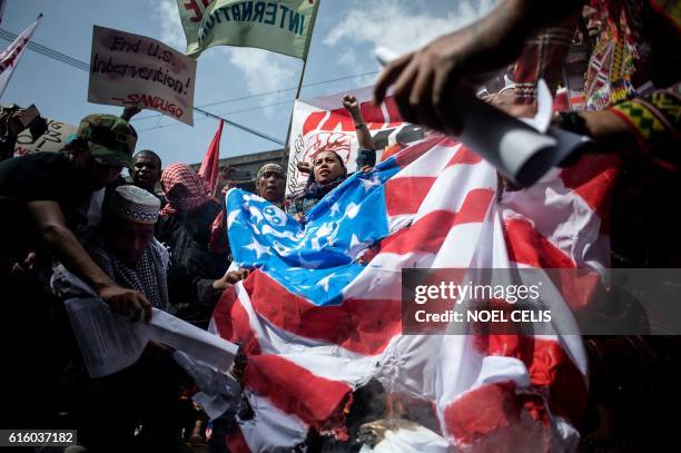 Members of an indigenous group and activists burn a US flag during a protest calling for the immediate pull-out of US troops in the Philippines in...