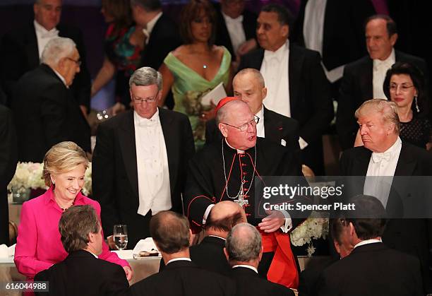 Standing between Cardinal Timothy Dolan, Hillary Clinton and Donald Trump attend the annual Alfred E. Smith Memorial Foundation Dinner at the Waldorf...