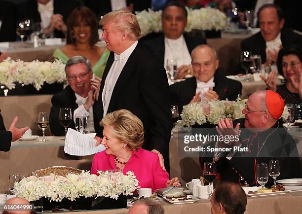 Donald Trump touches Hillary Clinton on the shoulder as he walks to the podium at the annual Alfred E. Smith Memorial Foundation Dinner at the...