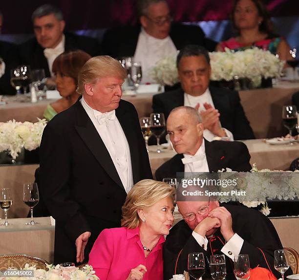 Cardinal Timothy Dolan speaks with Hillary Clinton as Donald Trump walks by at the annual Alfred E. Smith Memorial Foundation Dinner at the Waldorf...