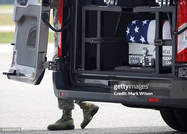 The door is being closed on a mortuary van containing the remains of U.S. Army Sgt. Douglas J. Riney, during a dignified transfer at Dover Air Force...