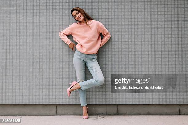 Sofya Benzakour , is wearing an H&M pink pull over, Uniqlo blue denim jeans, and Public Desire pink heels shoes, on October 21, 2016 in Paris, France.