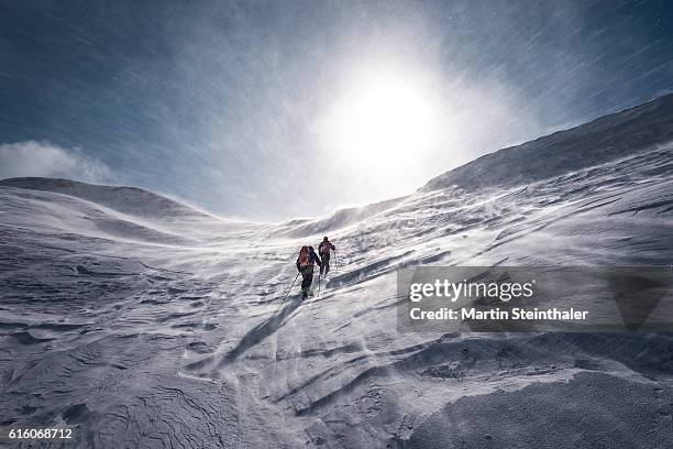 explorer on skiing tour with icy snowstorm - extreme skiing photos et images de collection