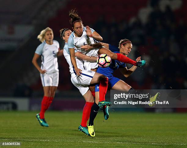 Jade Moore and Jo Potter of England challenge Eugenie Le Sommer of France during the Women's International Friendly match between England and France...