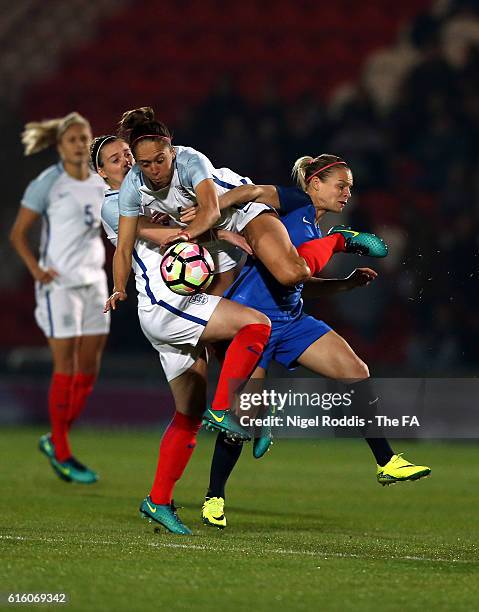 Jade Moore and Jo Potter of England challenge Eugenie Le Sommer of France during the Women's International Friendly match between England and France...